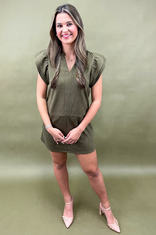 Woman wearing a green dress against a matching background