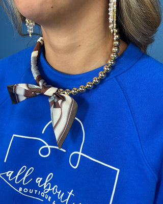 Shop the Half Beaded Scarf Necklace in multiple colors! Features polished gold-tone beads, patterned scarf details, and a sty