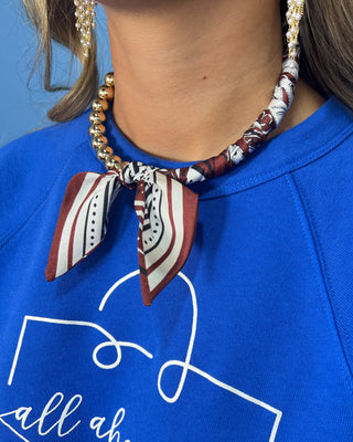 Shop the Half Beaded Scarf Necklace in multiple colors! Features polished gold-tone beads, patterned scarf details, and a sty