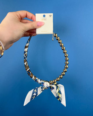 Shop the Half Beaded Scarf Necklace in multiple colors! Features polished gold-tone beads, patterned scarf details, and a sty