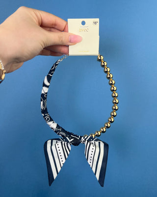Shop the Half Beaded Scarf Necklace in multiple colors! Features polished gold-tone beads, patterned scarf details, and a sty