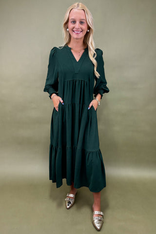 Woman wearing a green dress against a beige background