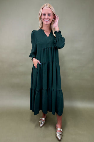 Woman wearing a green dress against a plain background