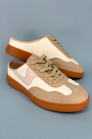 Pair of beige and brown sneakers on a gray background