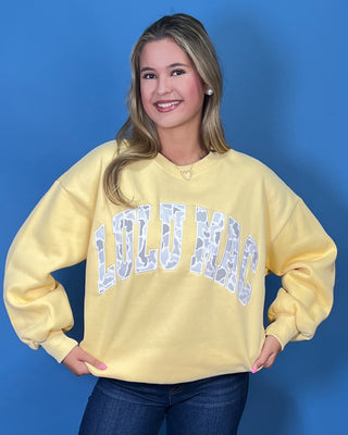 Lulu Mac Buttercream Camo Varsity Crewneck featuring a cozy fleece-lined interior, oversized camouflage varsity applique, relaxed fit, and classic collegiate style