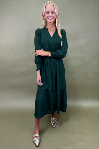 Woman wearing a green dress against a plain background