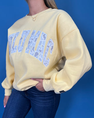 Lulu Mac Buttercream Camo Varsity Crewneck featuring a cozy fleece-lined interior, oversized camouflage varsity applique, relaxed fit, and classic collegiate style