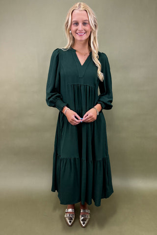 Woman wearing a green dress against a plain background