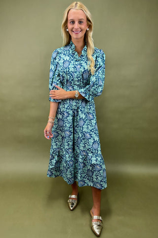 Woman wearing a blue floral dress against a green background
