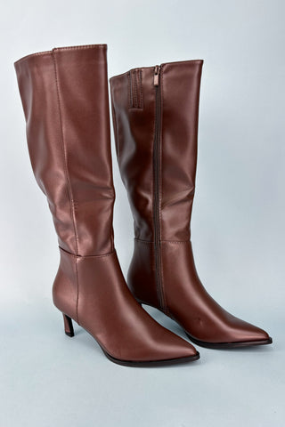 Pair of brown knee-high boots on a light gray background