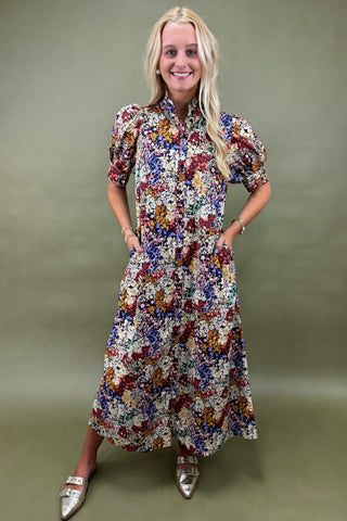 Woman wearing a colorful floral dress against a green background