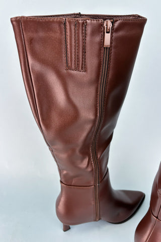Brown knee-high boot with a zipper on a light gray background