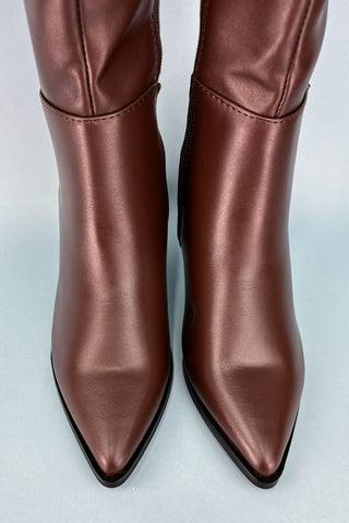 Pair of brown leather boots on a light gray background