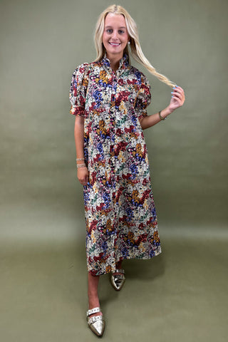 Woman wearing a floral dress against a plain background