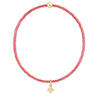 Necklace with pink beads and gold cross pendant on a white background