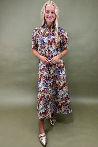 Woman wearing a floral dress against a plain background