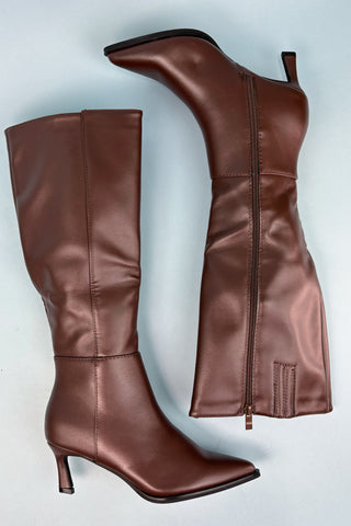 Brown knee-high boots with a high heel on a light blue background