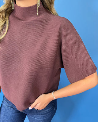 Chocolate brown short sleeve mock neck knit sweater with a subtle textured finish, relaxed fit, and wide sleeves.