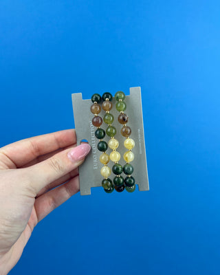 Shop the Olive Multi-Colored Beads Bracelet Set featuring glossy green, brown, and cream marbled beads with gold-tone accents for effortless everyday style.