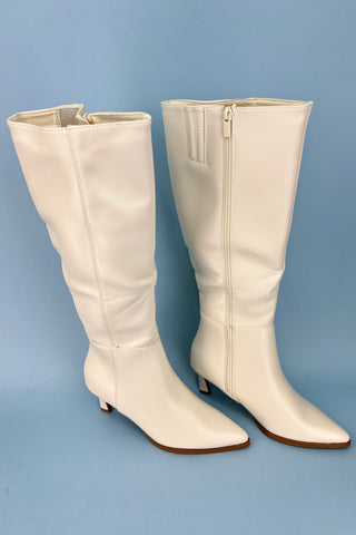 Pair of white knee-high boots on a blue background