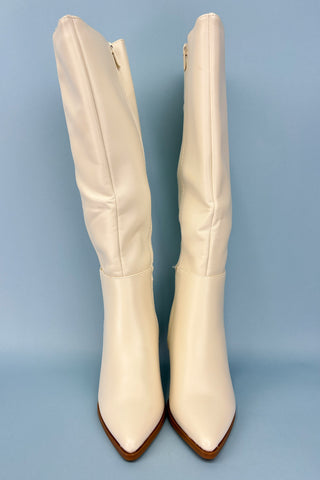 Pair of white knee-high boots on a light blue background