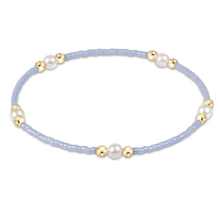 Bracelet with light blue beads, gold accents, and pearls on a white background