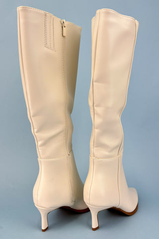 Beige knee-high boots on a light blue background
