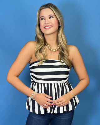 black and white striped strapless bubble hem top with a ruched bodice and flattering fit.