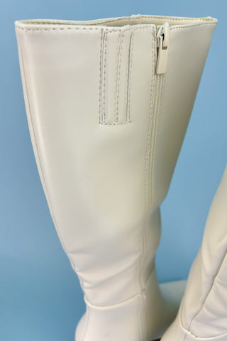 White knee-high boots on a light blue background