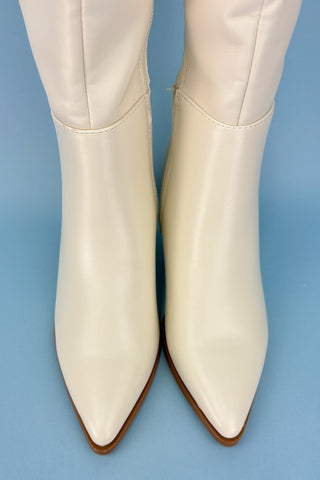 White ankle boots on a blue background