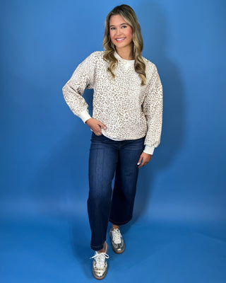Ivory long sleeve sweatshirt with a taupe leopard print, classic crew neckline, relaxed fit, and ribbed trim.