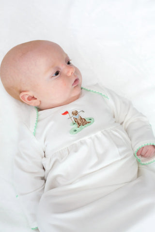 Baby wearing a white outfit with a small design on a white background