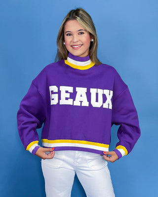 Person wearing a purple sweater with 'GEAUX' text on a blue background