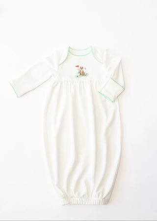 White baby gown with green trim on a white background
