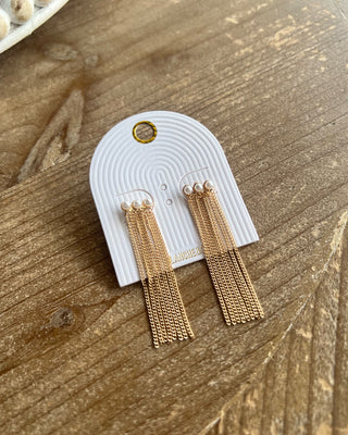 featuring delicate pearl accents and cascading gold fringe. Elegant statement jewelry for everyday wear and special occasions