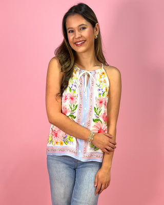 Woman wearing a floral sleeveless top against a pink background