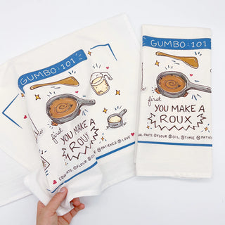 Two kitchen towels with Gumbo-themed illustrations and text on a white background.