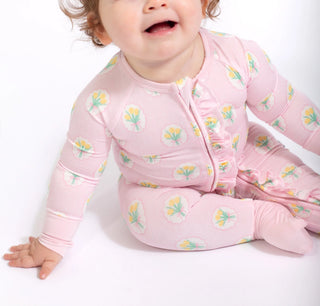 Baby wearing a pink floral onesie on a white background