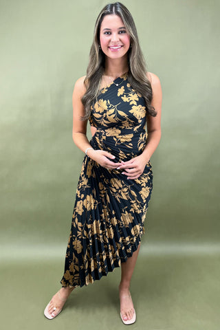 Woman wearing a black floral dress against a green background