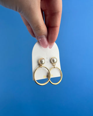 Shop the Eden Pearl Matte Gold Earrings featuring elegant pearl studs and open-circle gold drops. Perfect for everyday outfits, weddings, and special occasions.