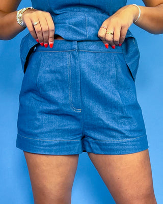 Person wearing blue shorts against a blue background
