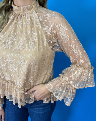 Champagne floral lace blouse with a high neckline, sheer long sleeves, tiered ruffle cuffs, and a feminine ruffle hem.