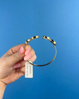 Shop the Claire Black & White Cuff Bracelet featuring glossy black stones, perl-inspired accents, and textured gold details for elegant everyday style.