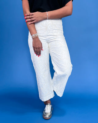Person wearing white pants on a blue background