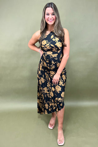 Woman wearing a black floral dress against a green background