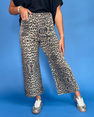 Person wearing leopard print pants on a blue background