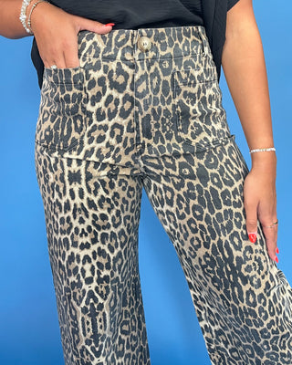 Leopard print pants worn by a person on a blue background