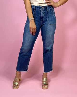 Person wearing blue jeans on a pink background
