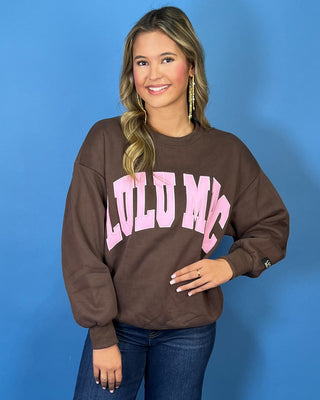 Chocolate brown Lulu Mac graphic crewneck sweatshirt with bold pink varsity lettering, long sleeves, ribbed trim, and a relaxed fit.