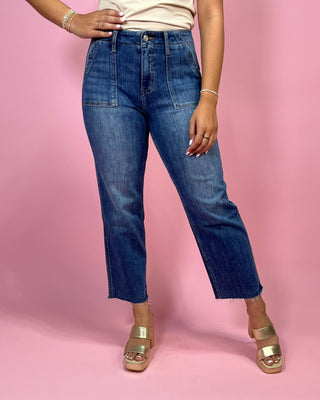 Person wearing blue jeans on a pink background